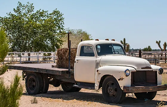 An old white truck parked in the desert for the Best Cash for Junk Cars content.